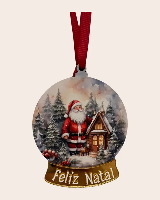 Enfeite em forma de globo de neve, com o Pai Natal à porta de uma casa de madeira entre pinheiros nevados, e base dourada em espelho onde se lê «Feliz Natal».